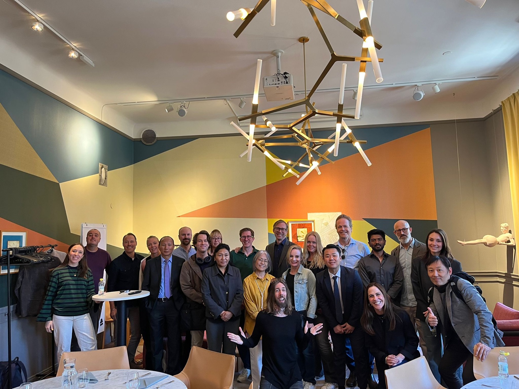 Forum participants gathered for a group photo in a colourfully decorated room in Stockholm